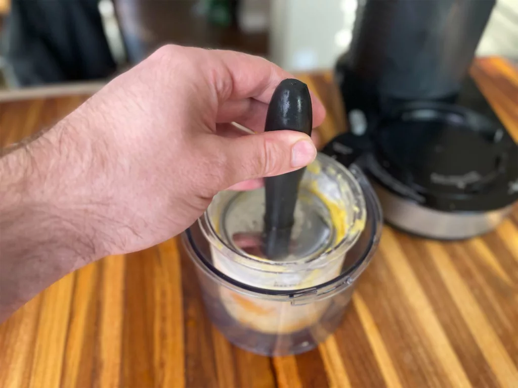 Tamping down Ninja CREAMi leftovers using a meat tenderizer.