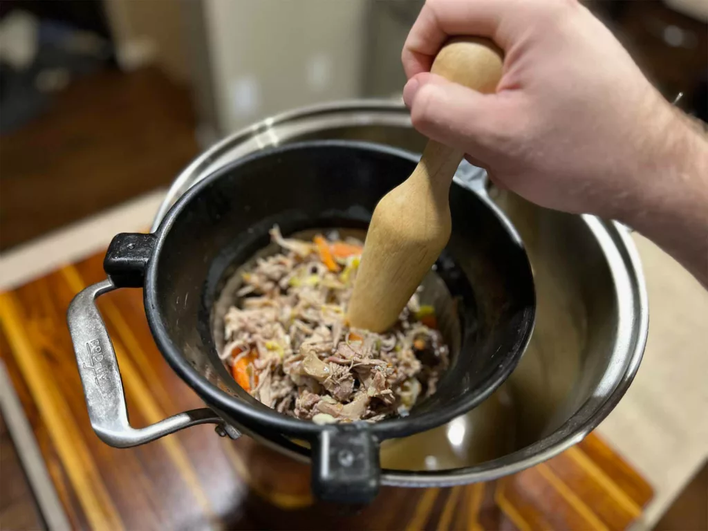 Extracting every last bit of liquid from ingredients inside the Matfer Bourgeat Bouillon Strainer/Chinois.